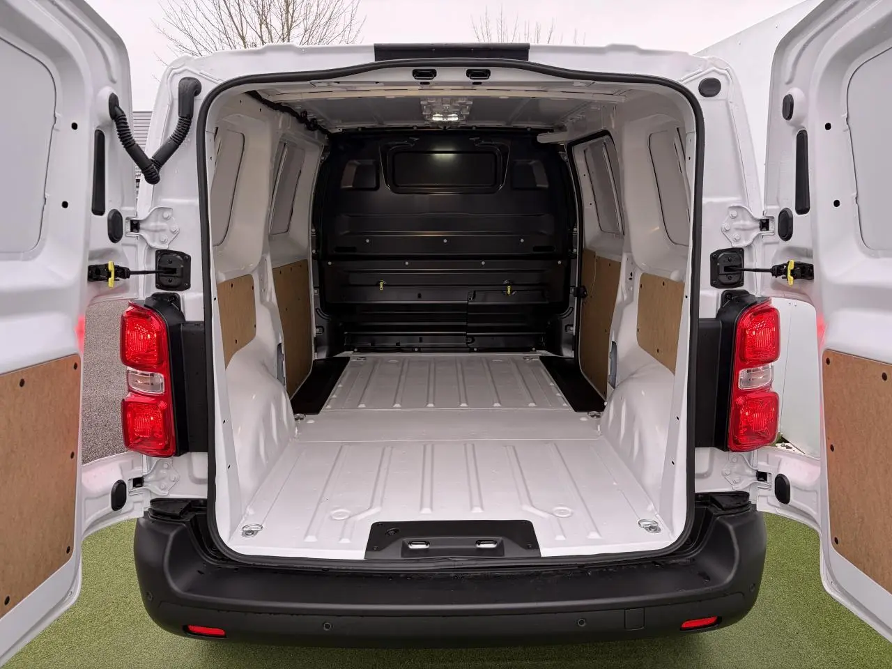 Vue arrière ouverte du Peugeot Expert Fourgon blanc Icy, montrant l'espace de chargement vide avec éclairage LED intégré.