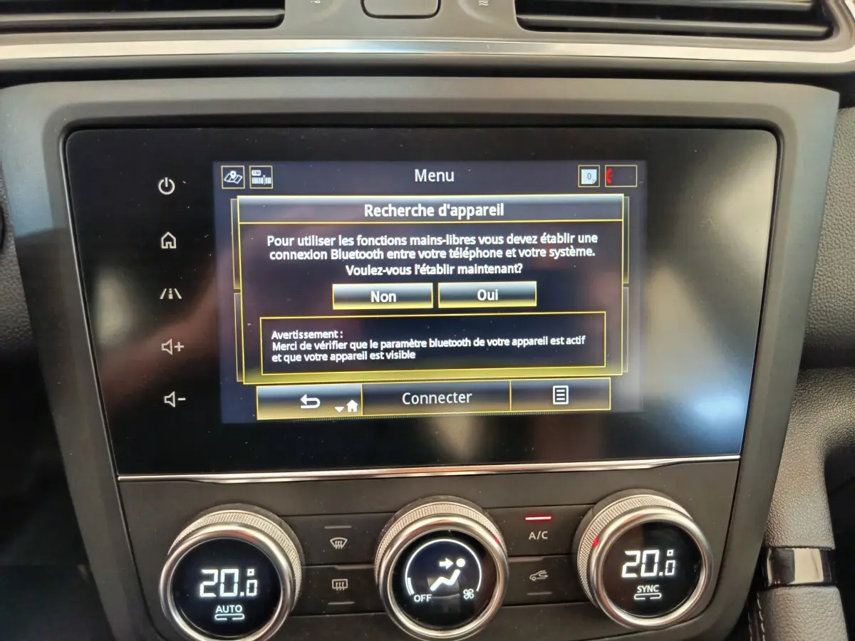 Gros plan sur l’écran tactile central et la commande de climatisation du Renault Kadjar Business Blue dCi 115 EDC 2022 gris foncé.