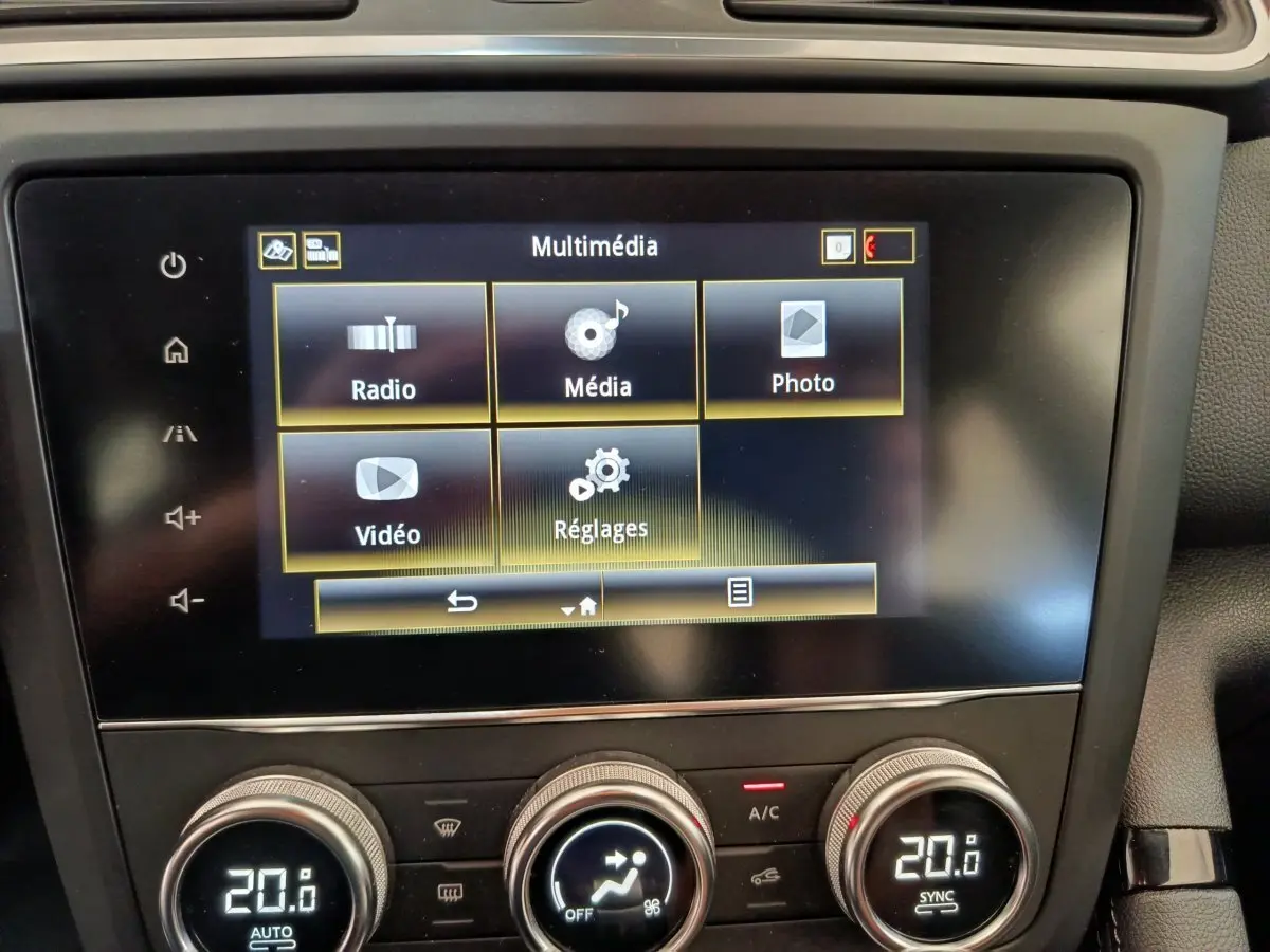 Écran tactile multimédia et commandes de climatisation digitale du tableau de bord du Renault Kadjar gris foncé.