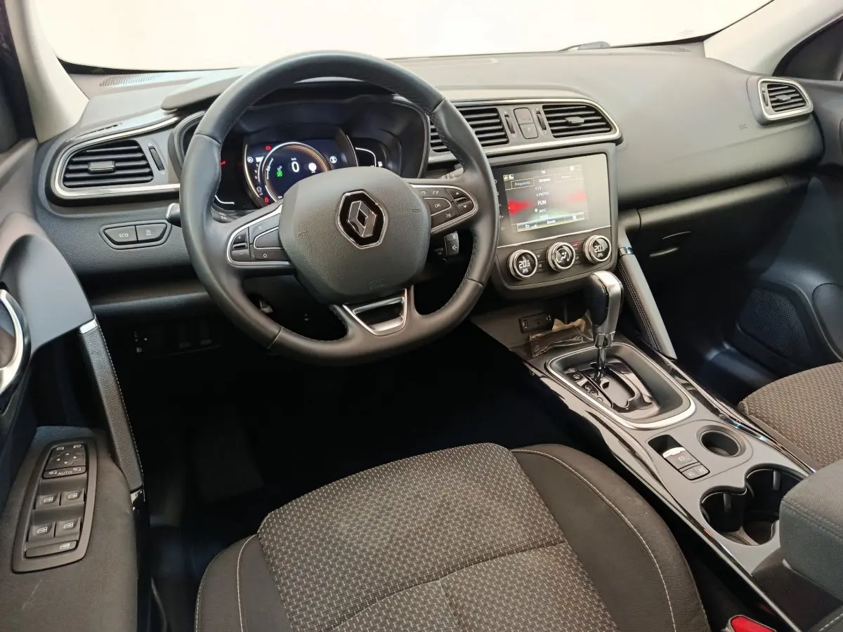 Vue intérieure du tableau de bord et volant du Renault Kadjar Business Blue dCi 115 EDC 2022 en gris foncé, avec écran tactile central.