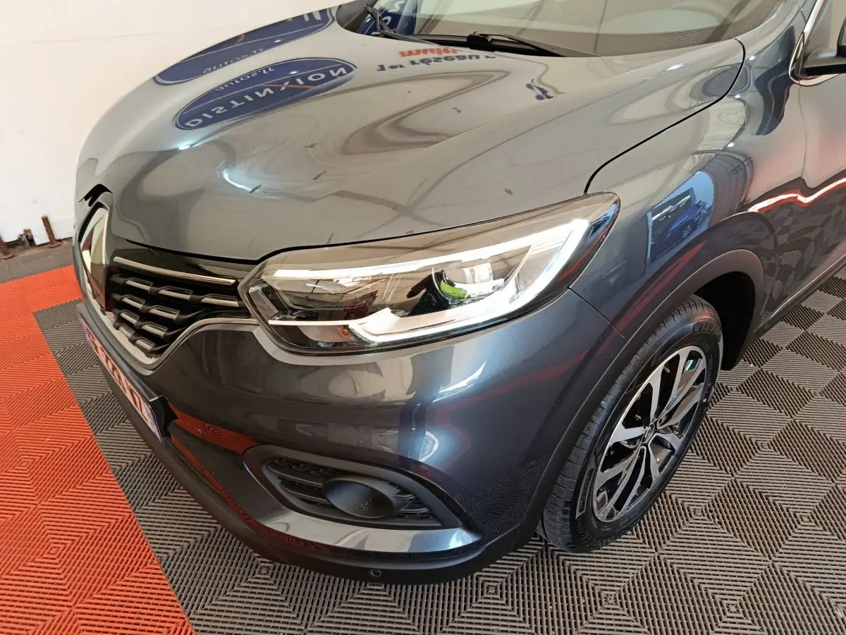 Vue 3/4 avant droit du Renault Kadjar Business gris foncé, mettant en valeur le phare LED et la calandre distinctive.