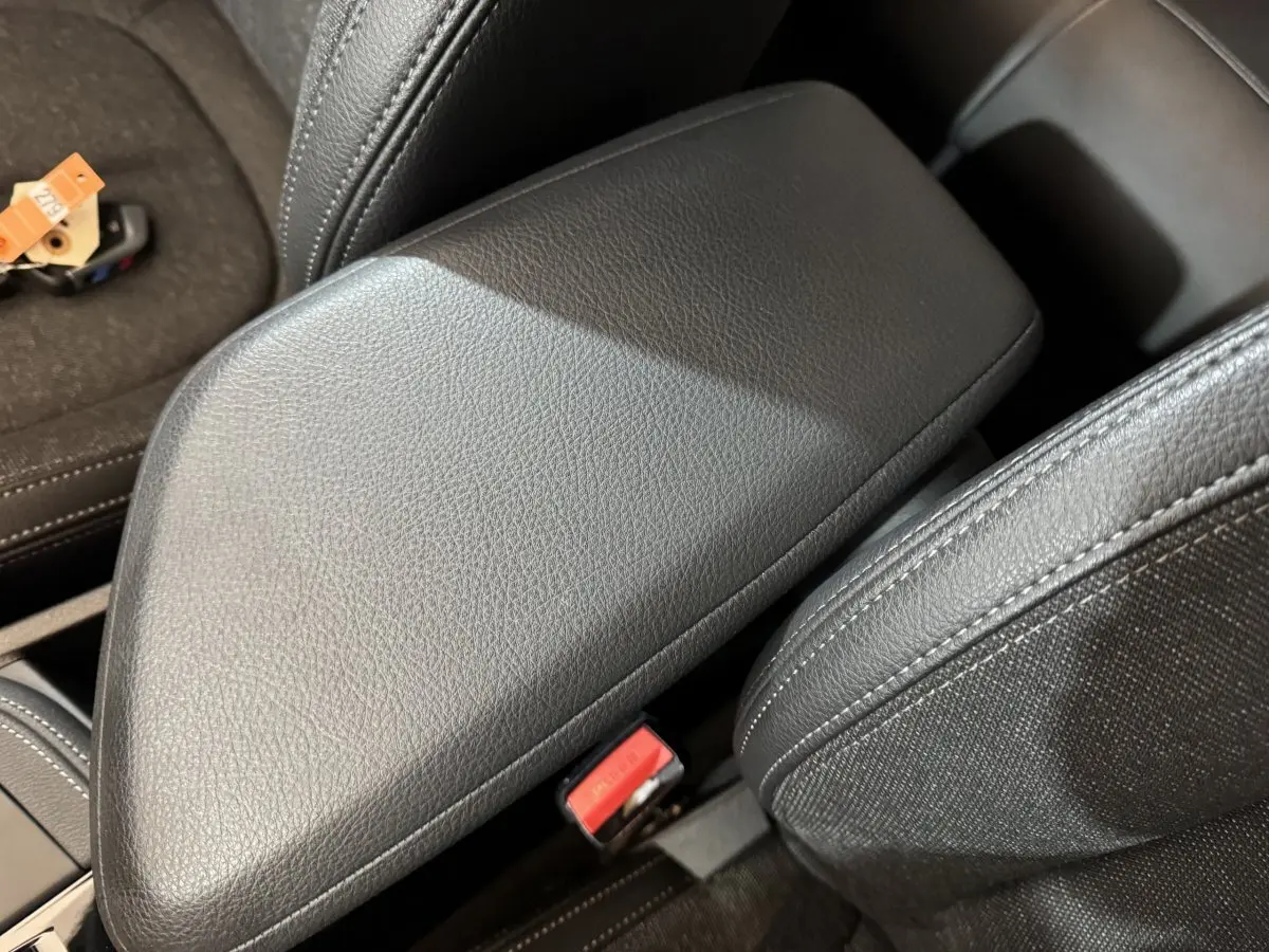 Gros plan sur l'accoudoir central en cuir noir de l'intérieur du BMW X2 xDrive25e M Sport BVA6 2021.