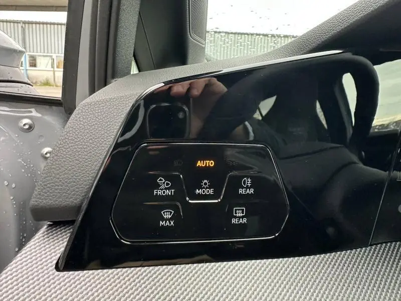 Gros plan sur le panneau de commande d’éclairage intérieur noir brillant dans une Volkswagen Golf gris Urano.