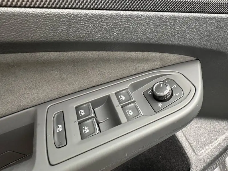 Commande des vitres et réglage des rétroviseurs côté gauche intérieur d'une Volkswagen Golf gris Urano 2026 R-Line.