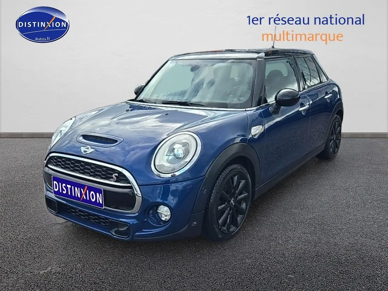 Vue 3/4 avant d'une MINI Cooper S bleu nuit avec jantes noires et toit noir sur fond neutre.