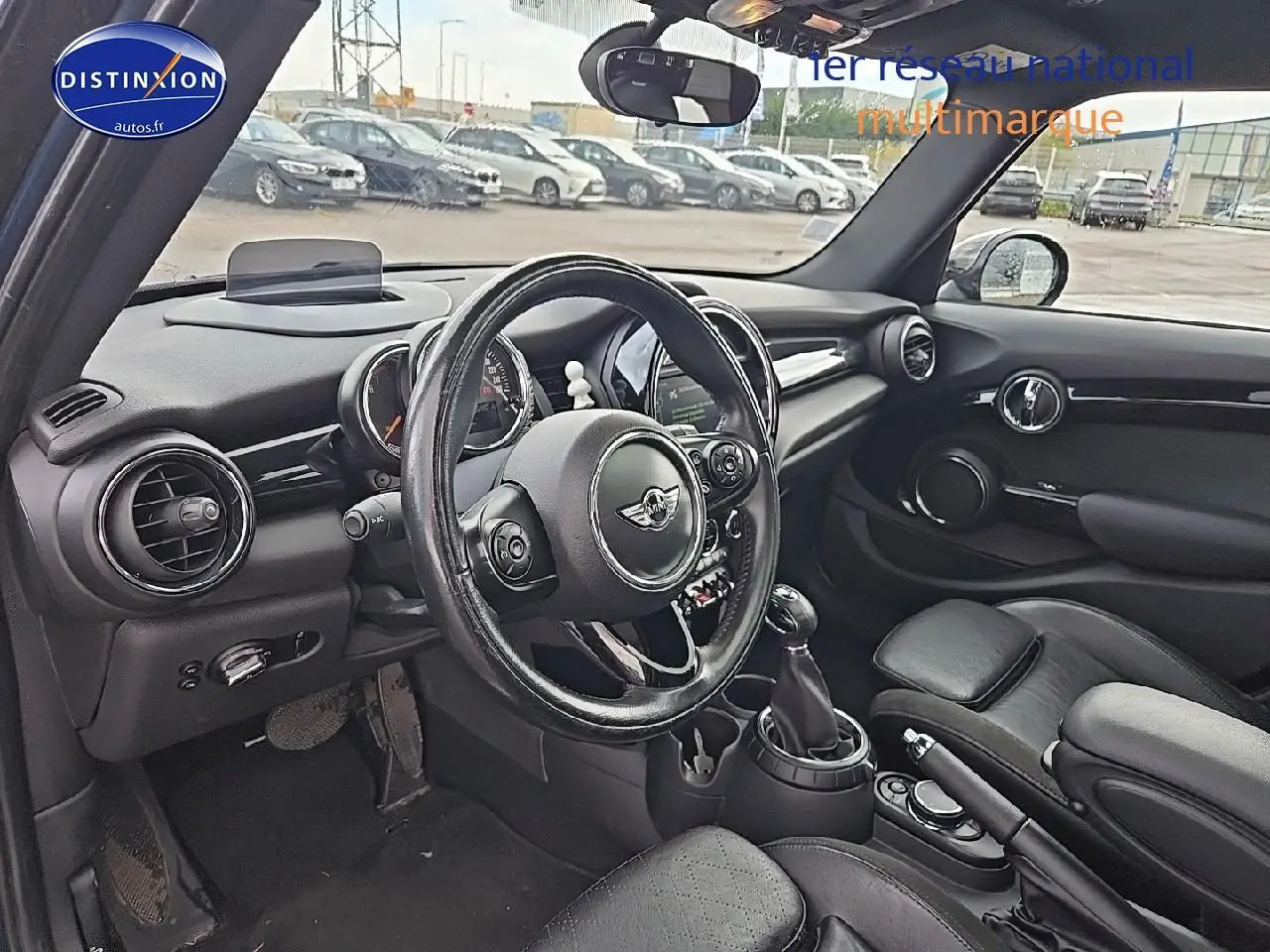 Intérieur noir de MINI Cooper S 2015 vu côté conducteur, avec volant cuir multifonction et tableau de bord rond.