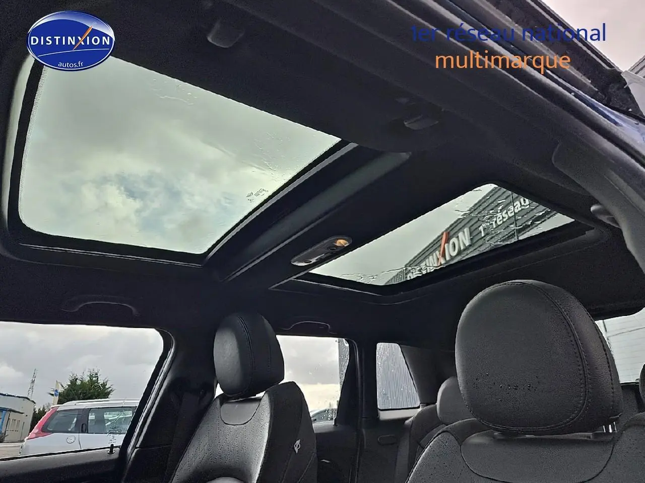 Vue intérieure du toit ouvrant panoramique et des sièges avant en cuir noir d'une MINI Cooper S bleu nuit 2015.