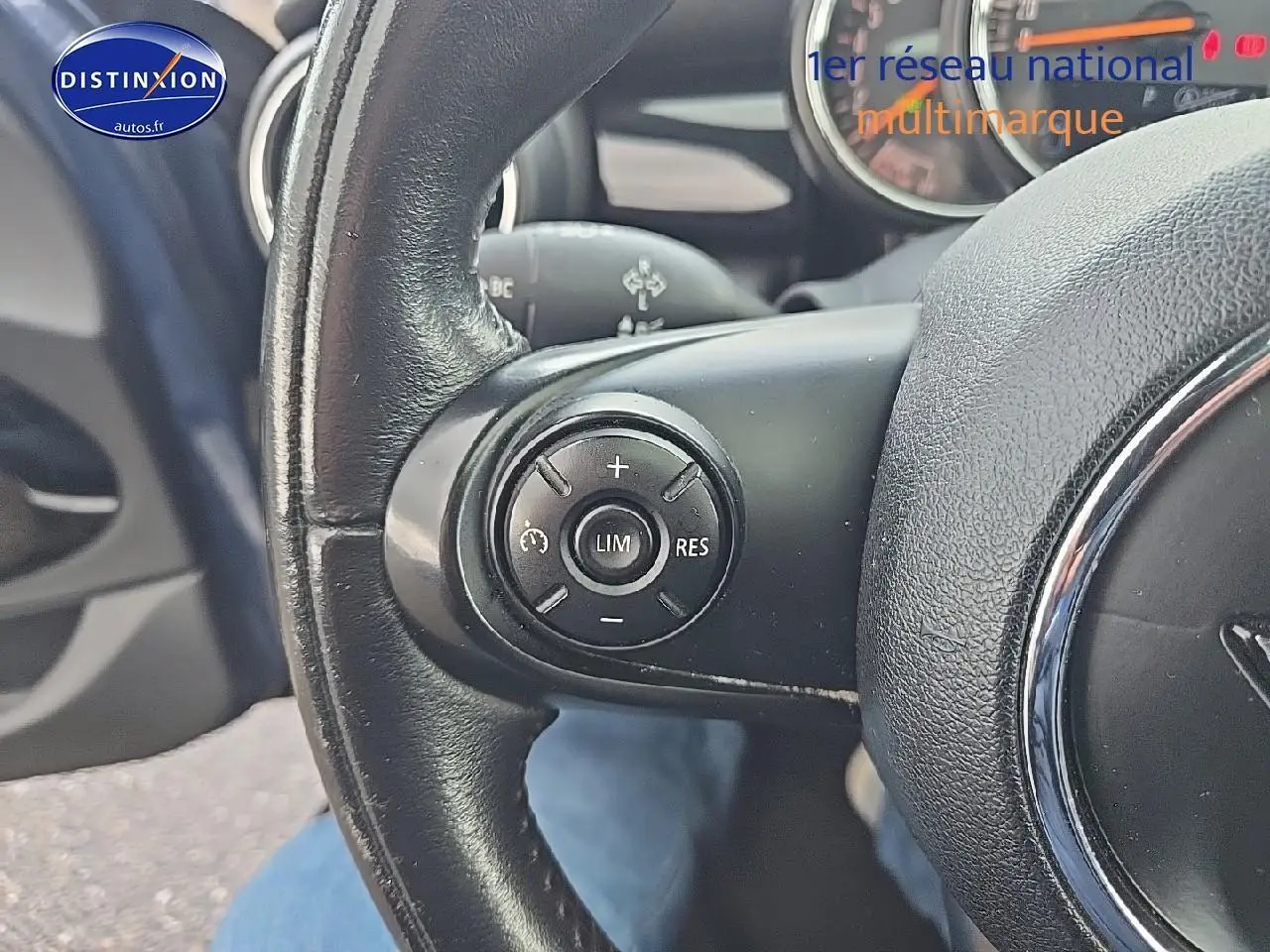 Gros plan sur le volant cuir noir de la MINI Cooper S 2015, avec commandes multifonctions côté gauche.