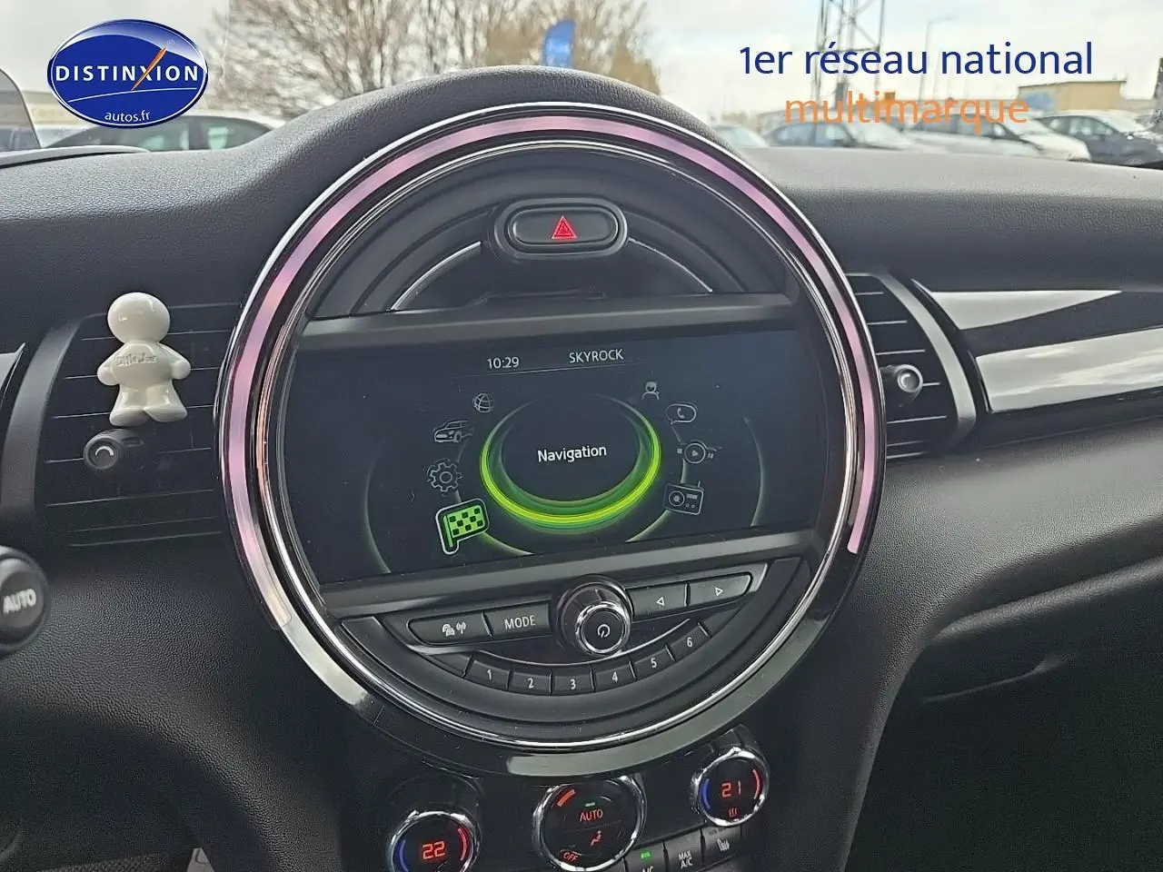 Vue rapprochée du tableau de bord de la MINI Cooper S 2015 avec écran central rond et éclairage d’ambiance rose.