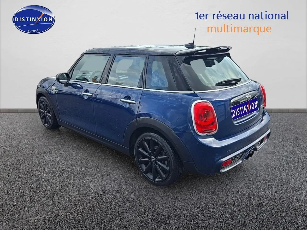 MINI Cooper S bleu nuit vue 3/4 arrière droit avec toit noir et jantes noires sur sol gris.