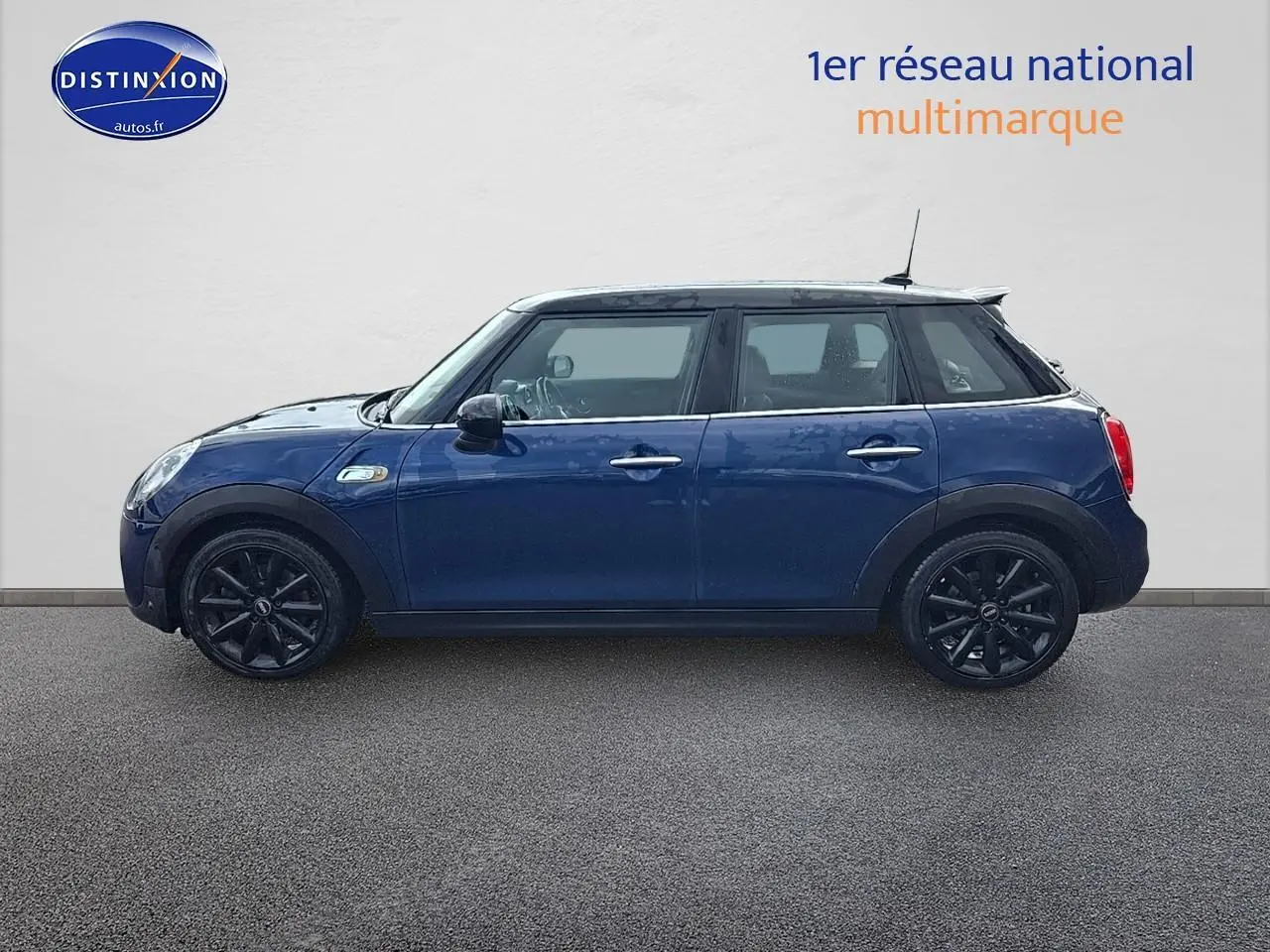 Profil latéral droit d'une MINI Cooper S 2015 bleu nuit avec jantes noires et toit blanc.