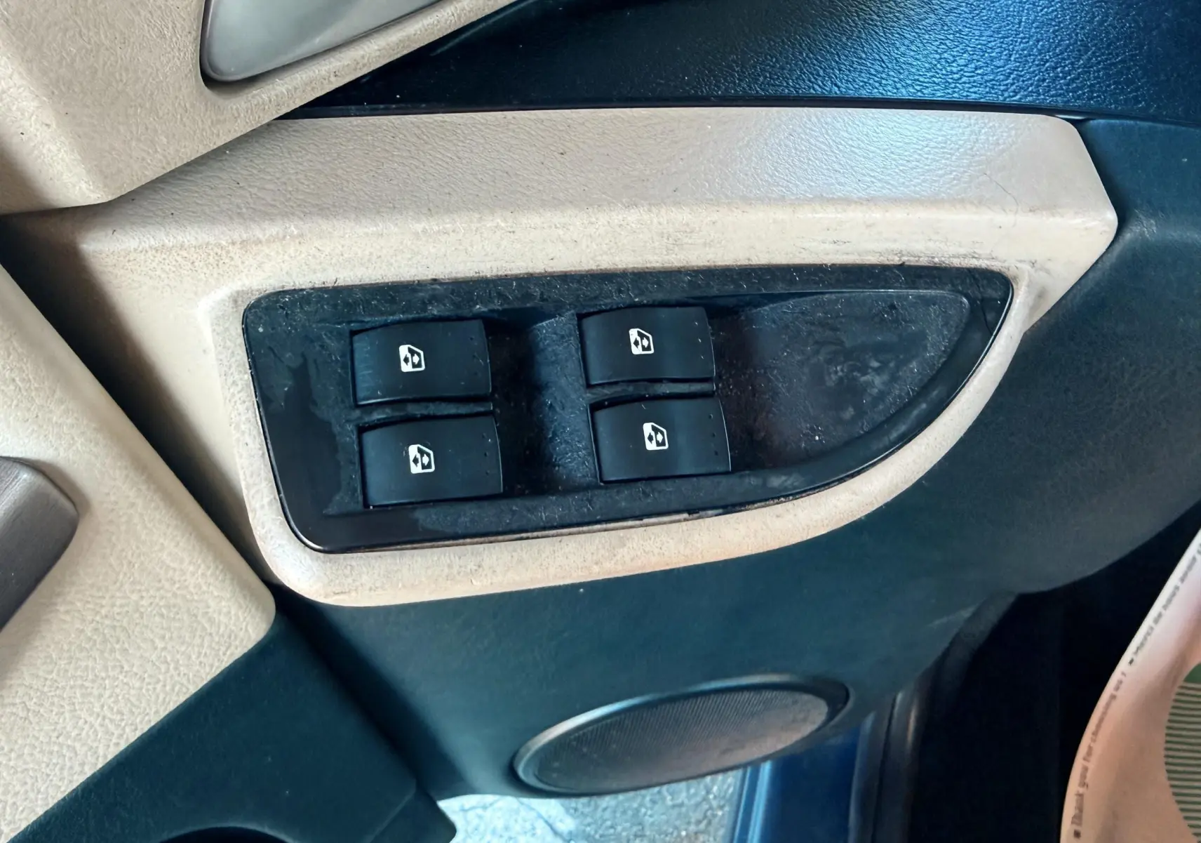 Gros plan sur les commandes des vitres électriques sur la portière avant gauche d'une Renault Avantime gris de 2002.