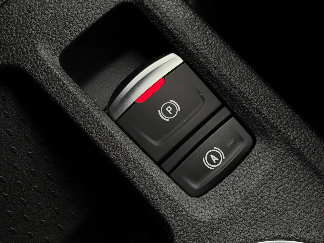 Gros plan sur les commandes du frein de parking électrique et de l'arrêt automatique dans l'habitacle du Renault Captur gris Cassiopée 2025.