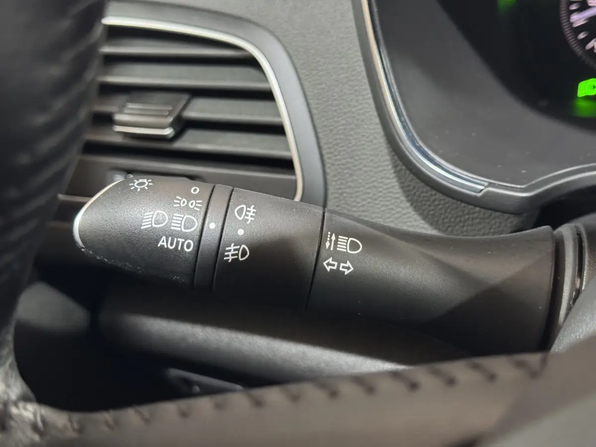 Gros plan sur la commande des phares et clignotants dans l’habitacle de la Renault Mégane Business gris clair.