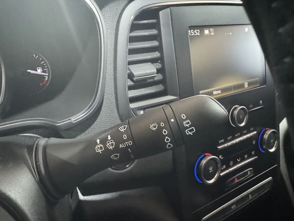 Vue intérieure rapprochée du commodo d’essuie-glace et du tableau de bord noir de la Renault Mégane Business gris clair.