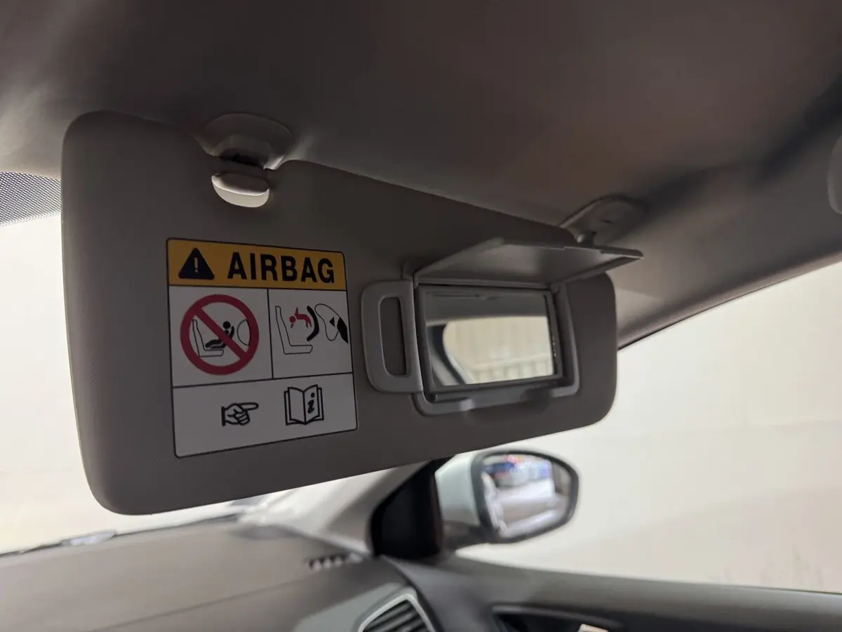 Détail du pare-soleil côté conducteur avec miroir et avertissement airbag, intérieur gris de la Renault Mégane Business.