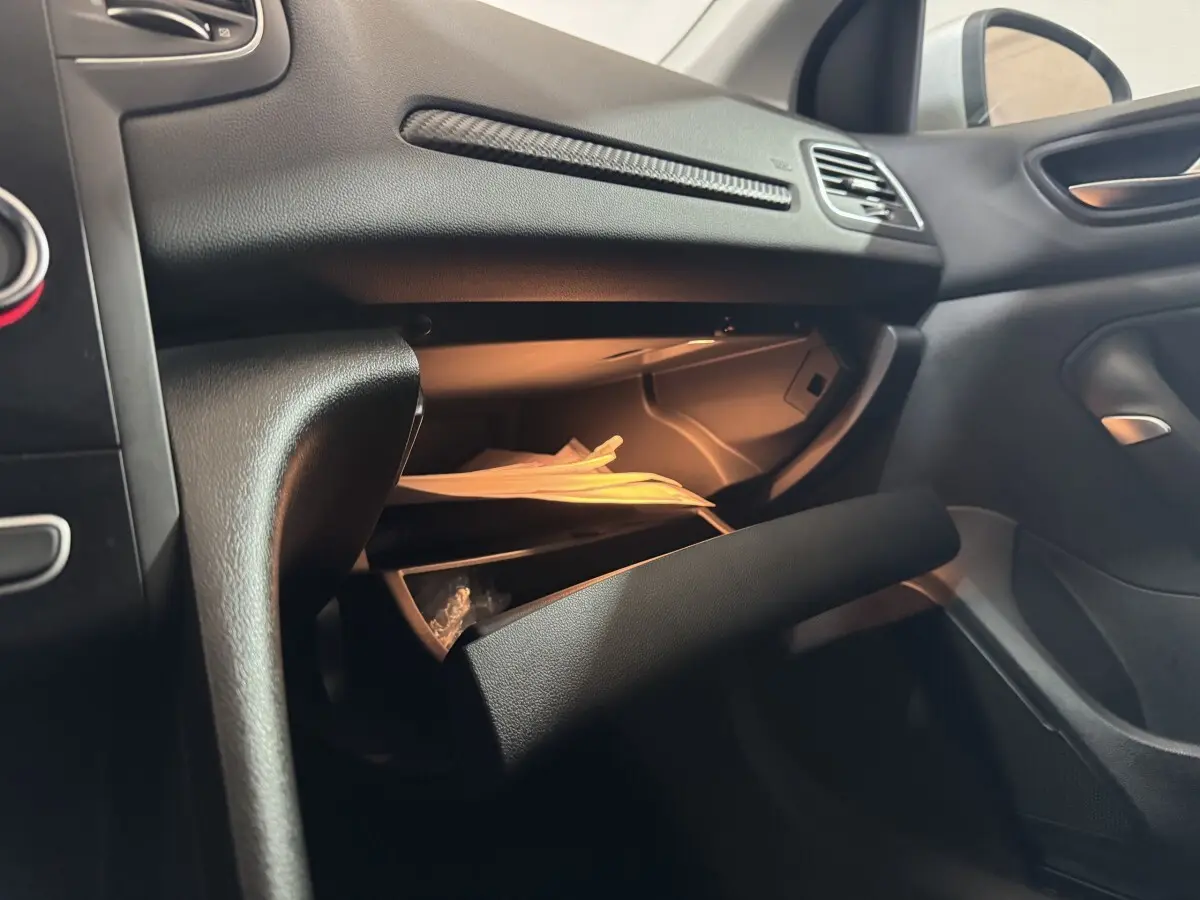 Vue intérieure côté passager de la Renault Mégane Business 2019, boîte à gants ouverte avec documents visibles.