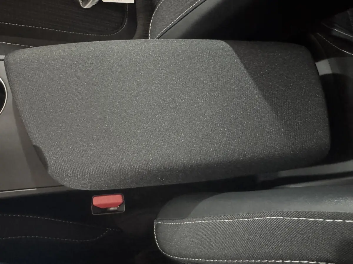 Gros plan sur l'accoudoir central noir et tissu gris foncé avec surpiqûres blanches dans une Renault Mégane Business 2019.