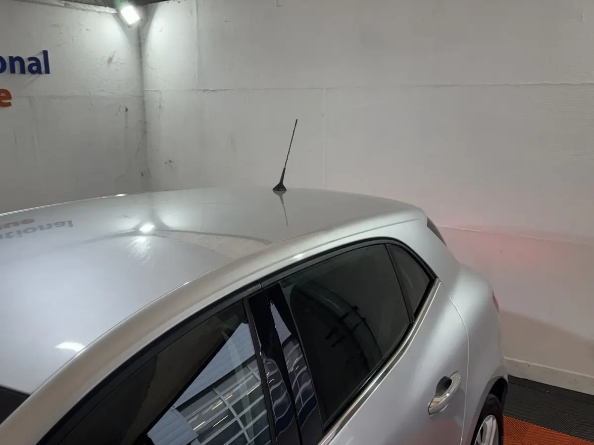 Vue 3/4 arrière droite d'une Renault Mégane Business gris clair avec antenne de toit et vitres teintées.