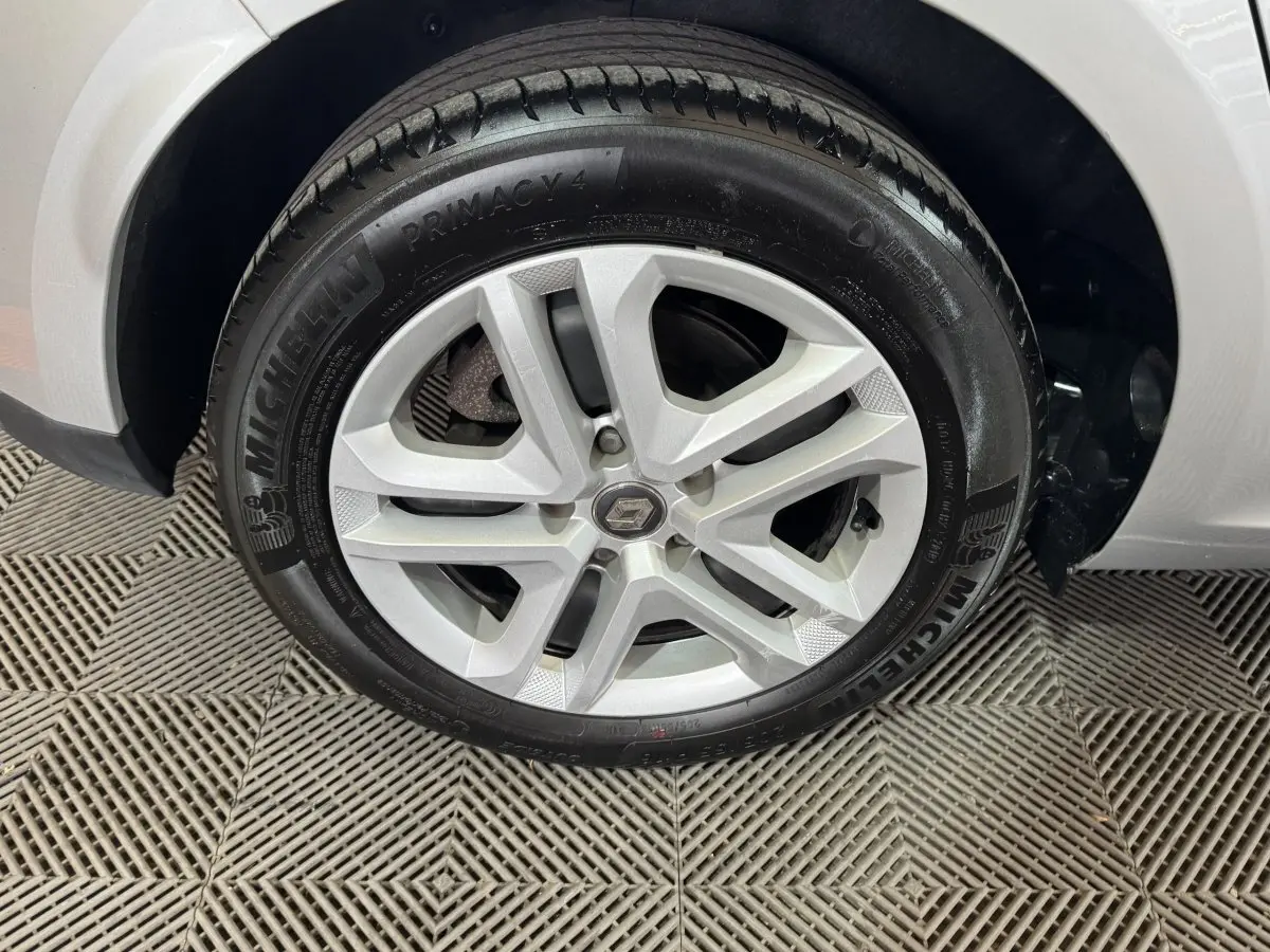 Gros plan sur la roue avant gauche grise d'une Renault Mégane Business TCe 140 avec jante alliage et pneu Michelin.