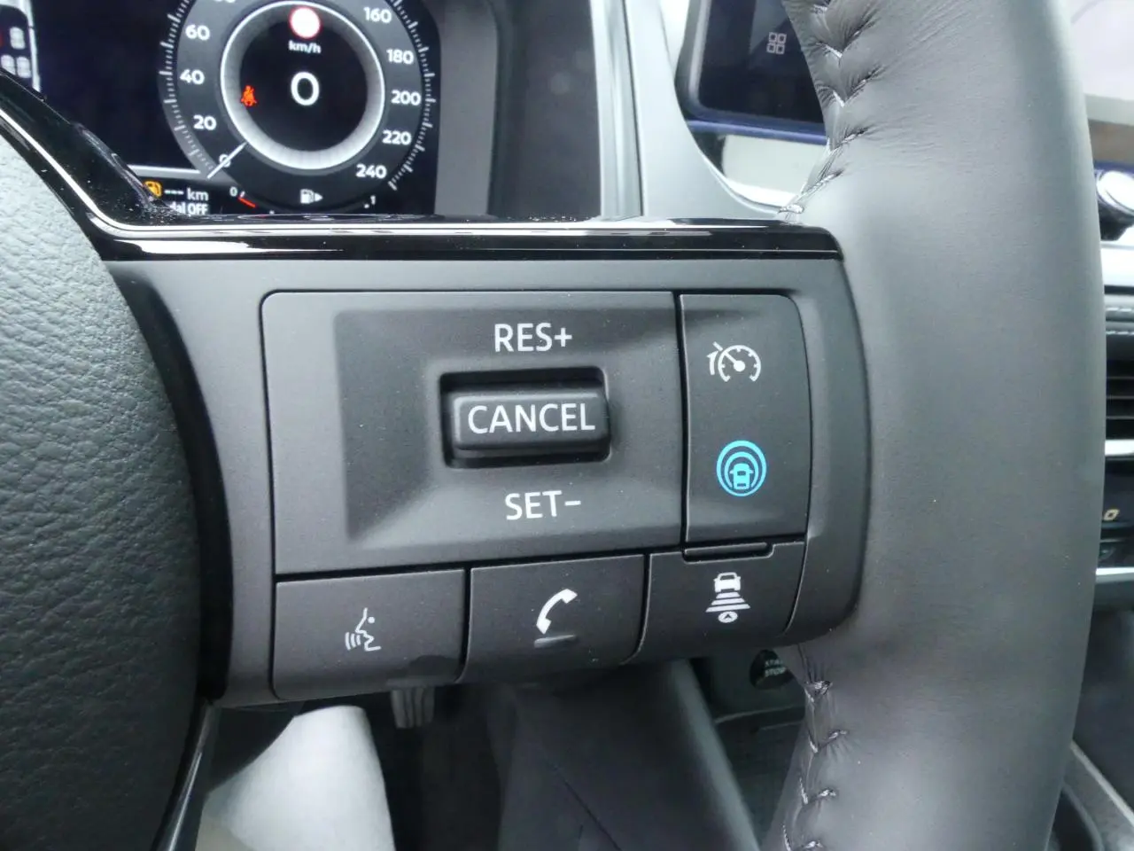 Gros plan sur les commandes du régulateur de vitesse au volant cuir du Nissan Qashqai gris métallisé 2025.