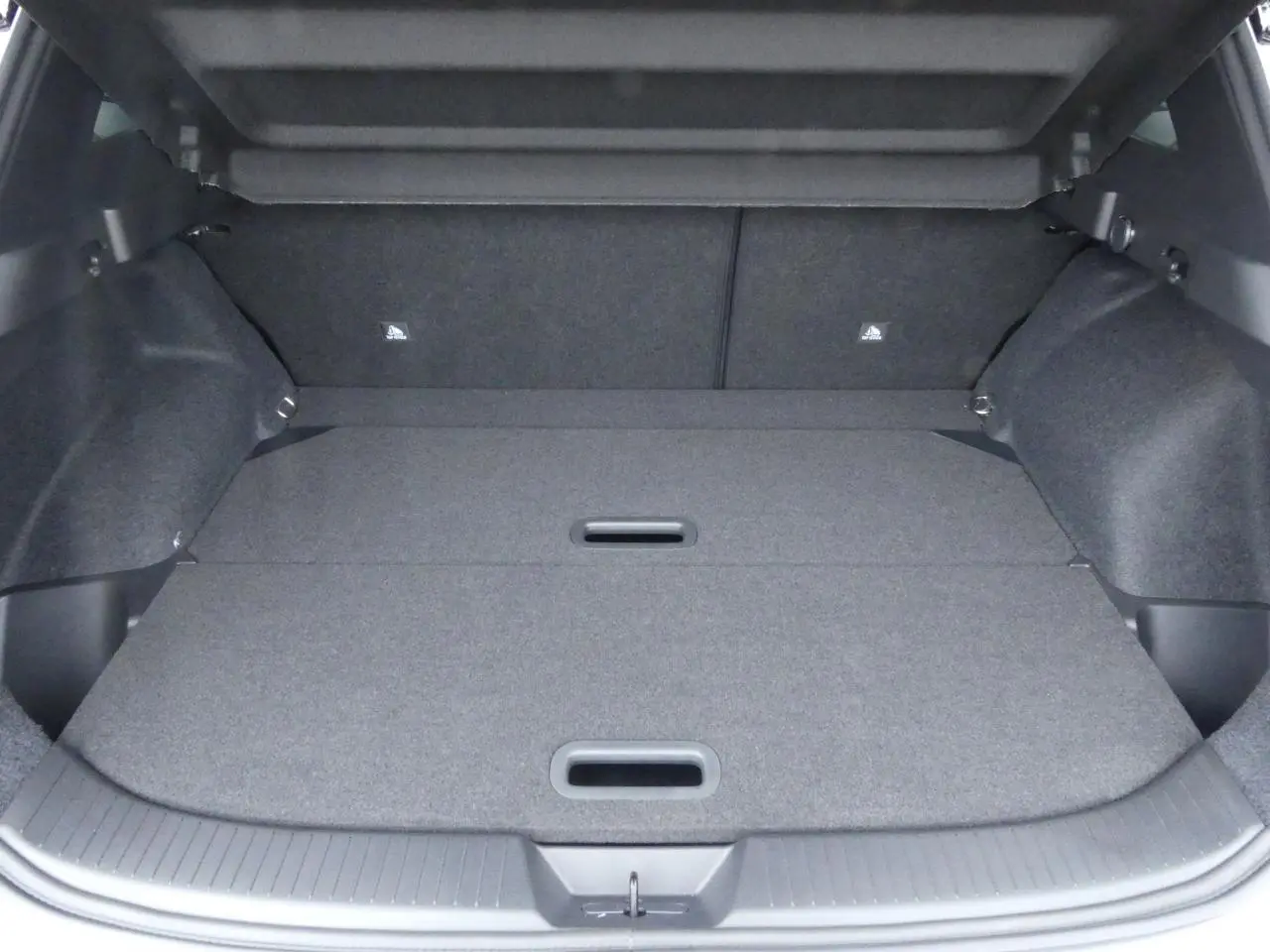 Coffre spacieux du Nissan Qashqai 1.5 e-Power gris métallisé, plancher modulable avec poignées intégrées.