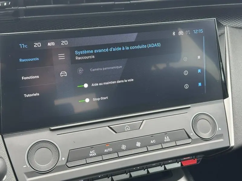 Écran tactile central du tableau de bord de la Peugeot 308 2024 affichant les aides à la conduite et commandes climatisation.