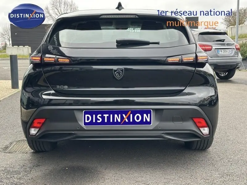 Vue arrière d'une Peugeot 308 2024 noire Perla Nera avec feux arrière à LED distinctifs et logo central.