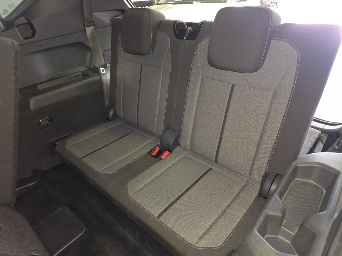 Vue intérieure du troisième rang de sièges tissu gris du SEAT Tarraco 1.5 TSI 7 places, avec ceintures et appuie-têtes.