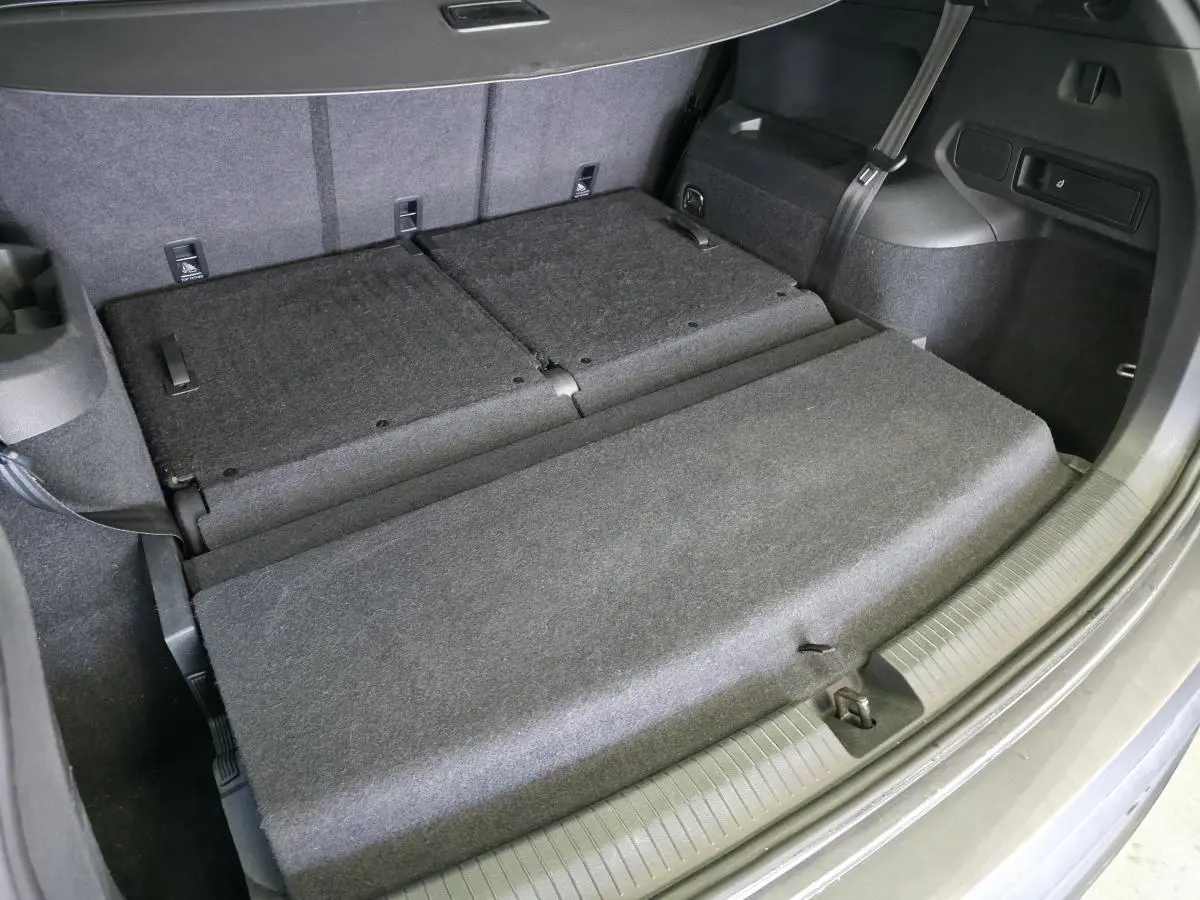 Coffre ouvert du SEAT Tarraco gris, vue plongeante sur banquette arrière rabattue et double plancher.