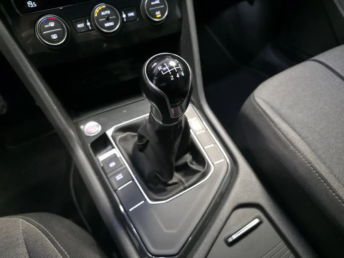 Gros plan sur le levier de vitesses manuel noir et la console centrale du SEAT Tarraco gris, avec commandes climatisation visibles.