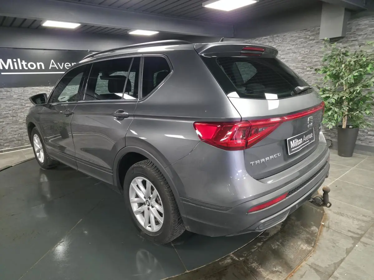 Vue 3/4 arrière droite du SEAT Tarraco gris avec crochet d'attelage escamotable et vitres surteintées.