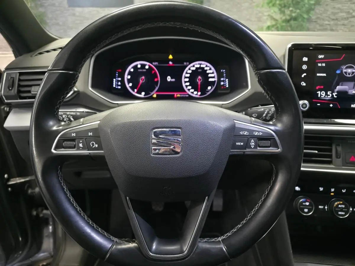 Vue rapprochée du volant cuir multifonction noir du SEAT Tarraco 2020 avec tableau de bord digital et écran tactile.
