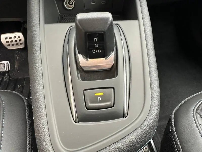 Gros plan sur la console centrale du Renault Captur 2026, levier de boîte automatique et bouton de parking, intérieur noir.
