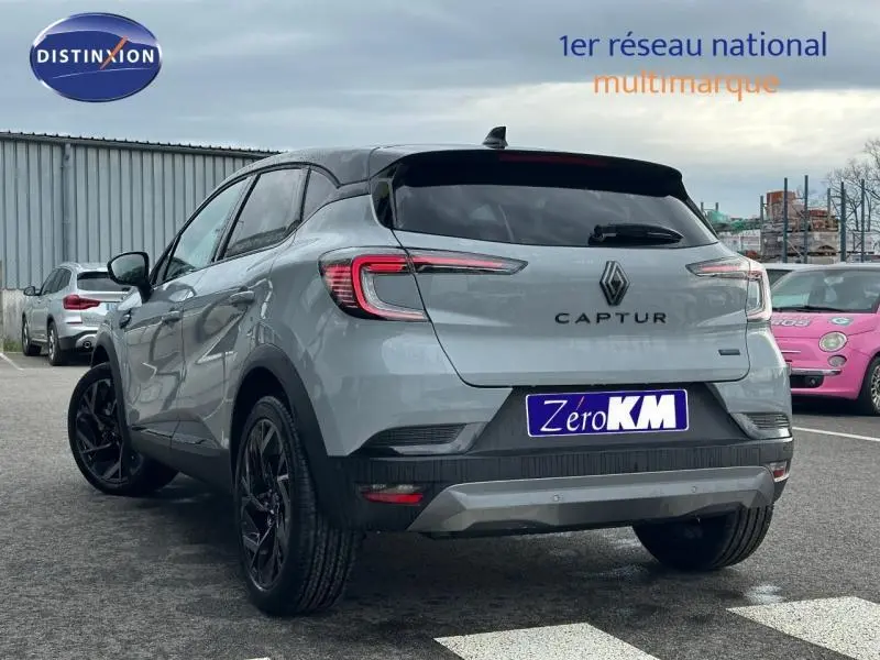 Vue 3/4 arrière droite du Renault Captur 2026 gris Rafale avec toit noir étoilé et jantes noires, stationné en extérieur.