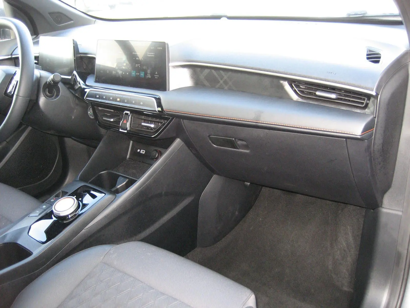 Vue intérieure côté passager du tableau de bord gris foncé du MG3 1.5 Hybrid Luxury avec écran tactile et console centrale moderne.