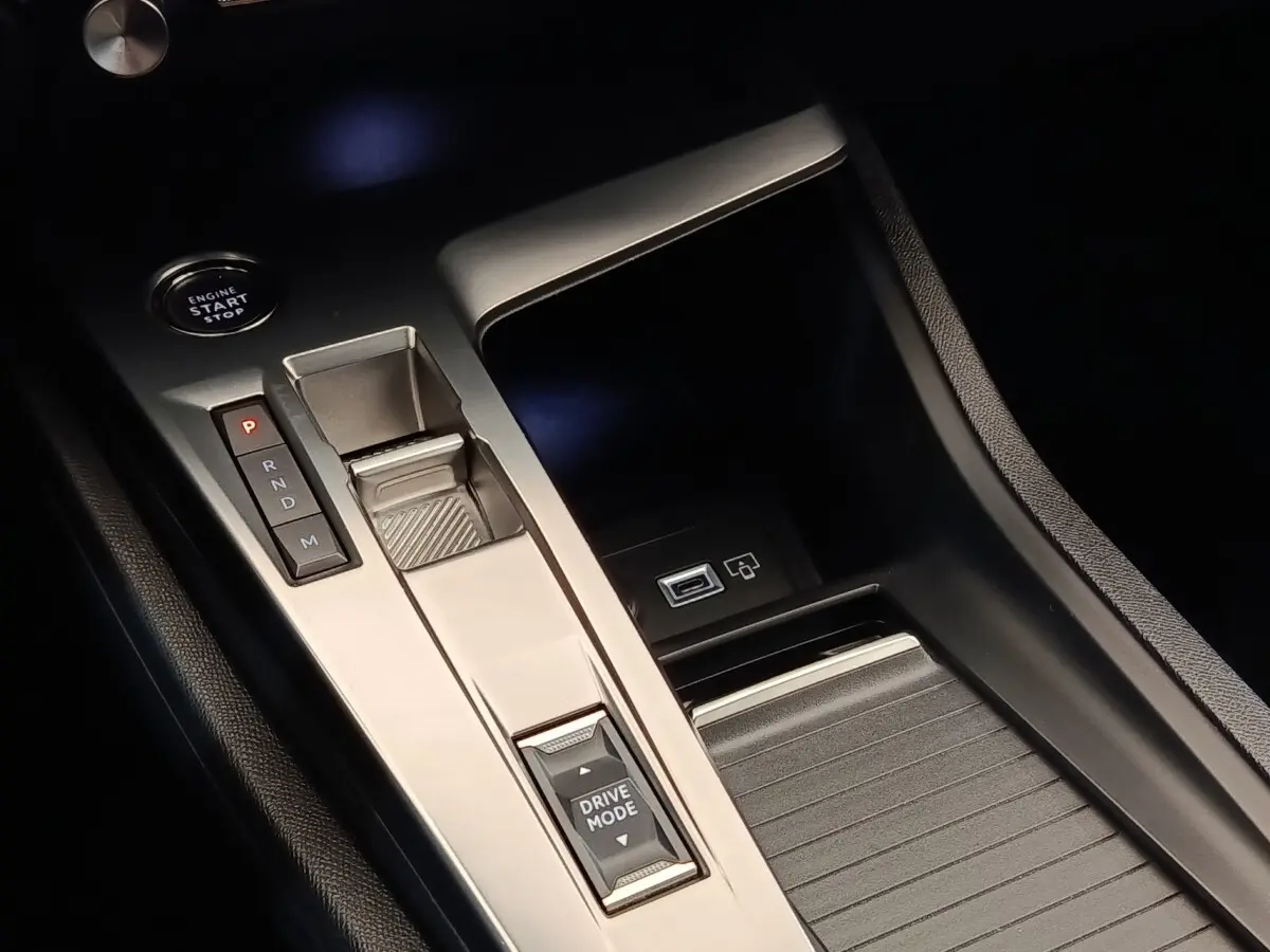 Gros plan sur la console centrale noire et argentée de la Peugeot 308 2023 avec bouton start, sélecteur de vitesses et commande Drive Mode.