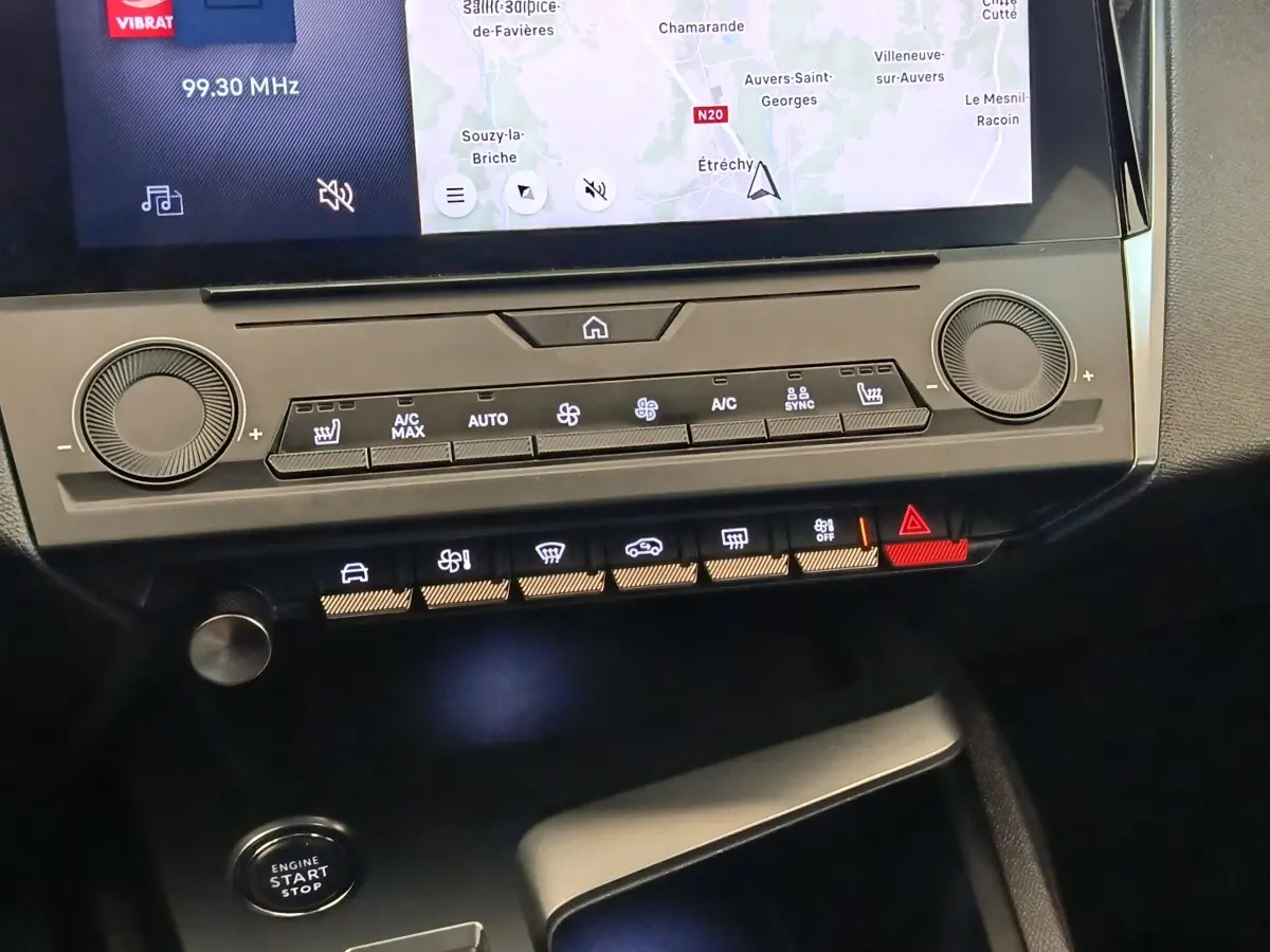 Gros plan sur la console centrale de la Peugeot 308 verte, montrant l'écran tactile et les commandes climatisation et démarrage.