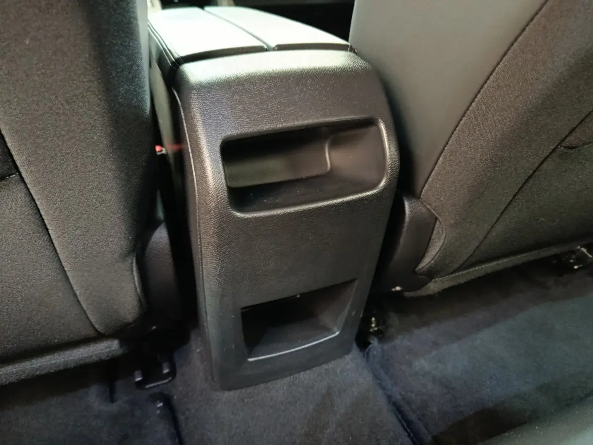 Vue rapprochée de la console centrale arrière noire entre les sièges arrière d'une Peugeot 308 2023.