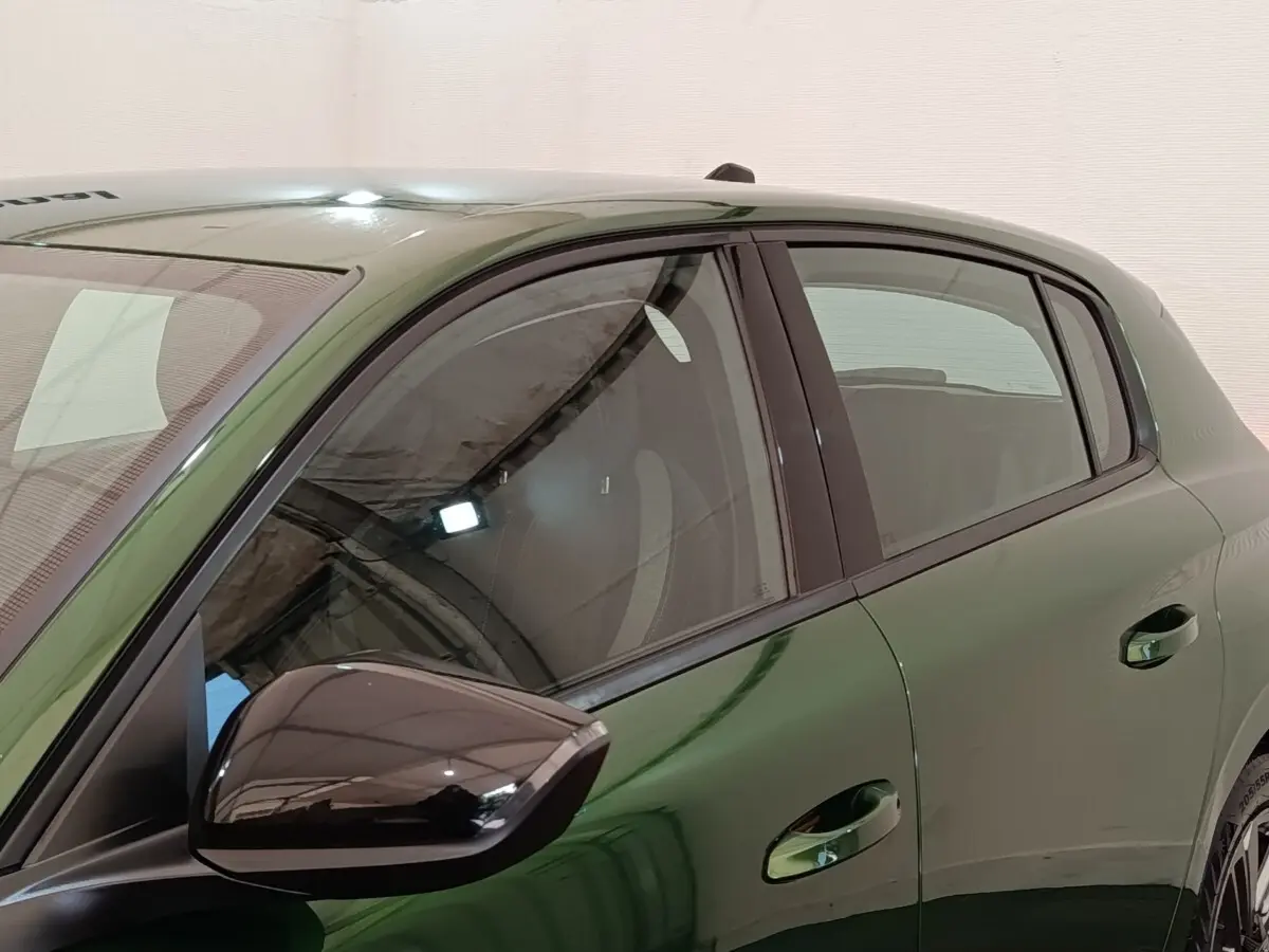 Vue latérale gauche rapprochée d’une Peugeot 308 2023 vert métallisé avec rétroviseur noir brillant.