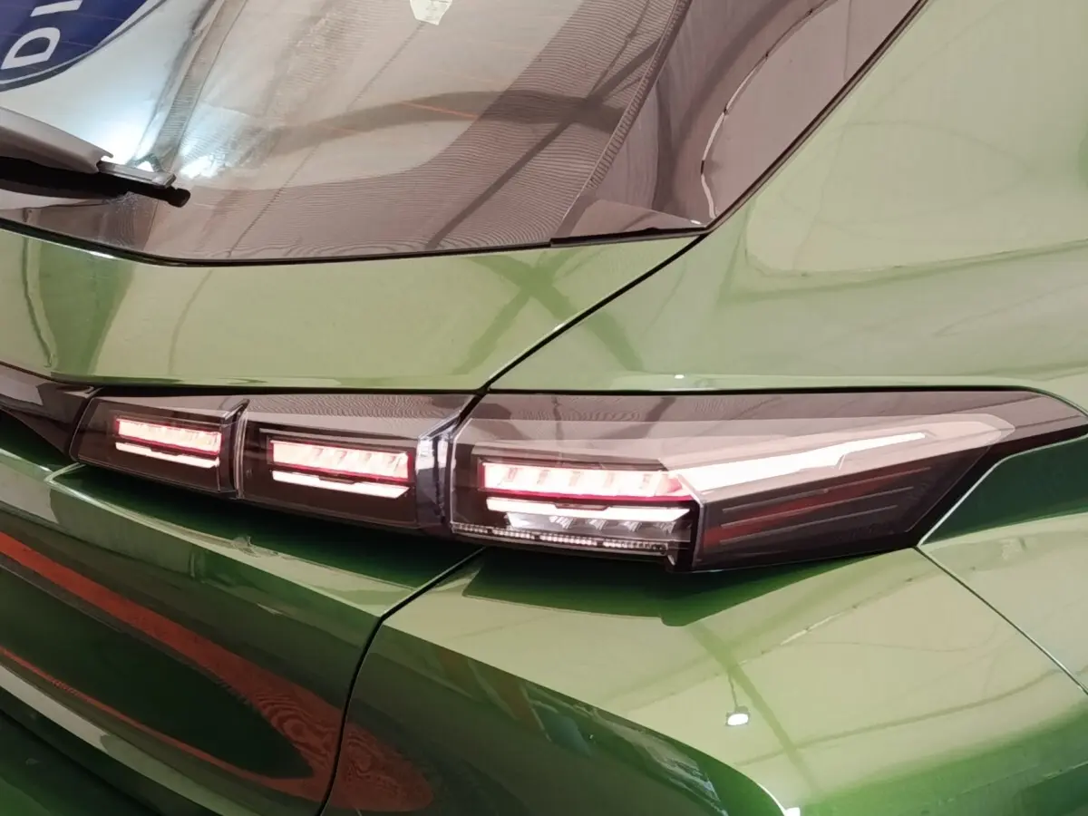 Gros plan sur le feu arrière droit rouge et blanc d'une Peugeot 308 2023 vert métallisé.