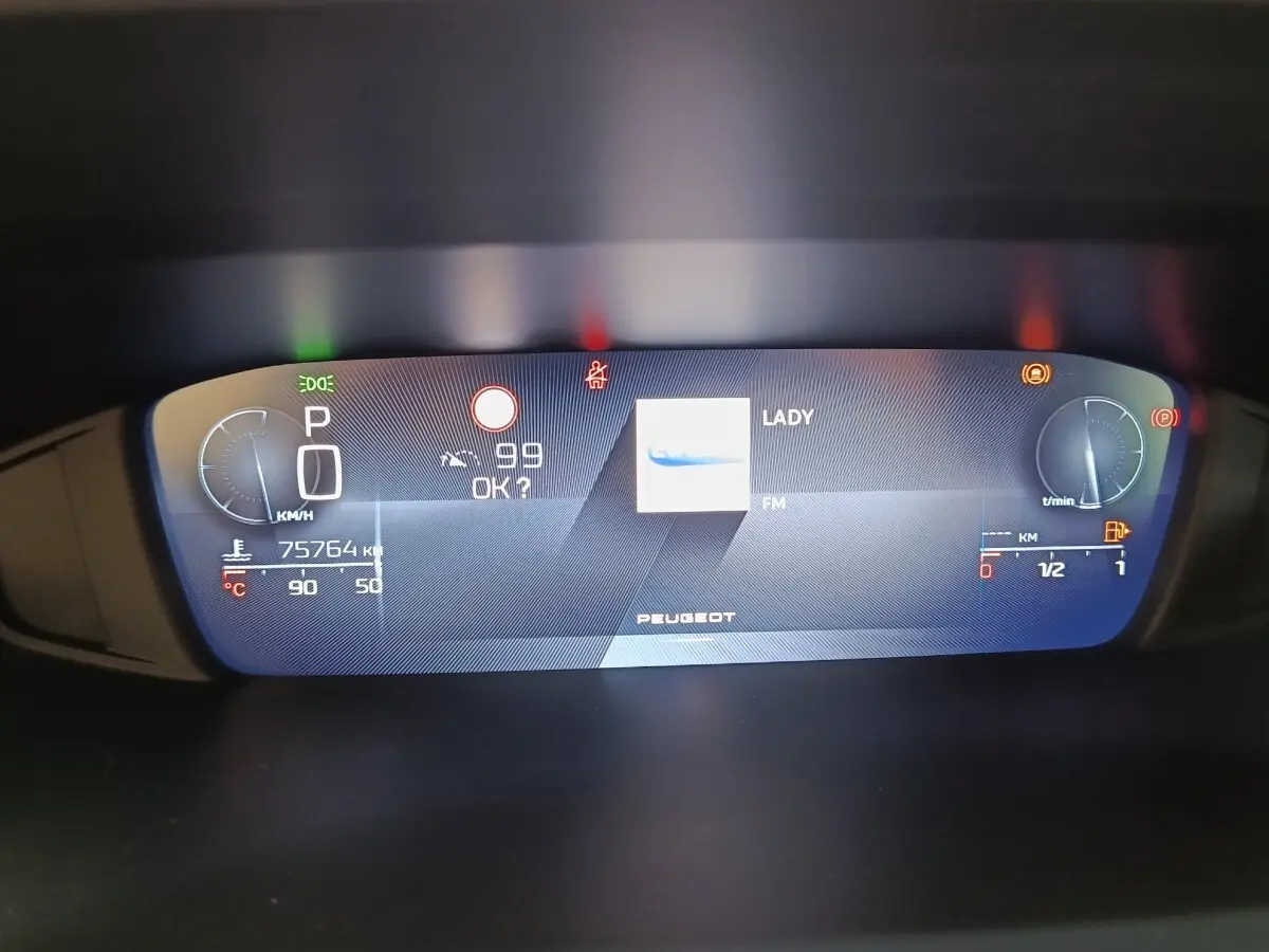 Affichage numérique du tableau de bord de la Peugeot 308 2023, avec vitesse, température et radio FM visible.