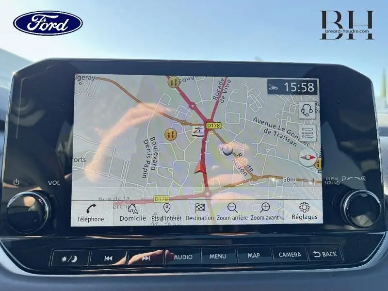 Écran tactile du système de navigation du Nissan Qashqai gris Argile, affichant une carte routière en intérieur.