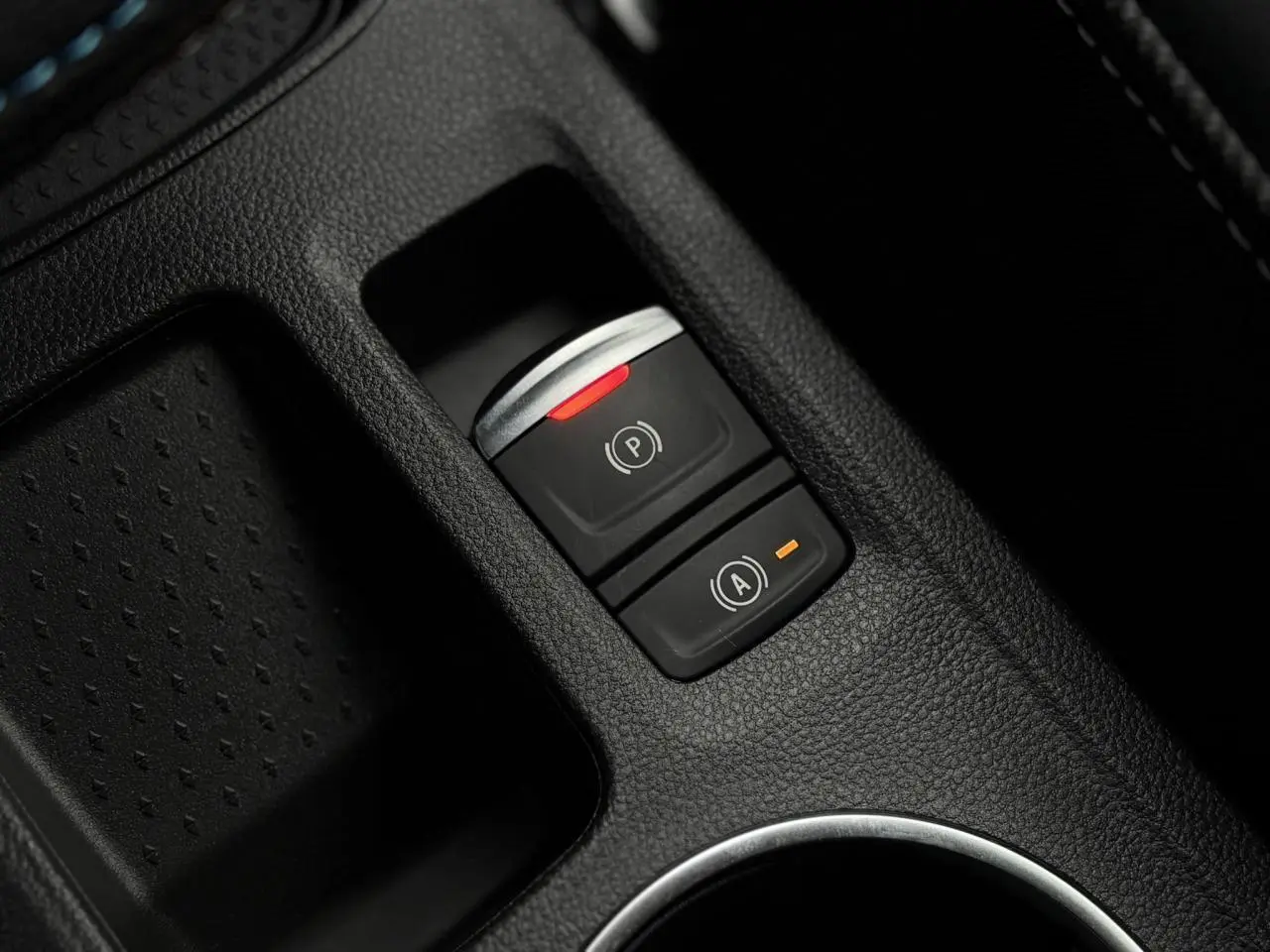 Détail intérieur du Renault Captur blanc nacré, montrant la console centrale avec surface texturée et porte-gobelet.