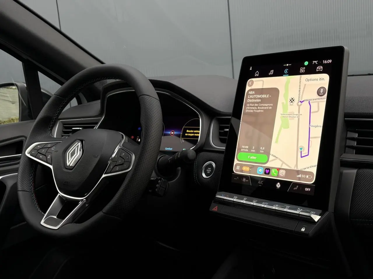 Vue intérieure du tableau de bord du Renault Captur blanc nacré avec écran tactile vertical et volant multifonction.