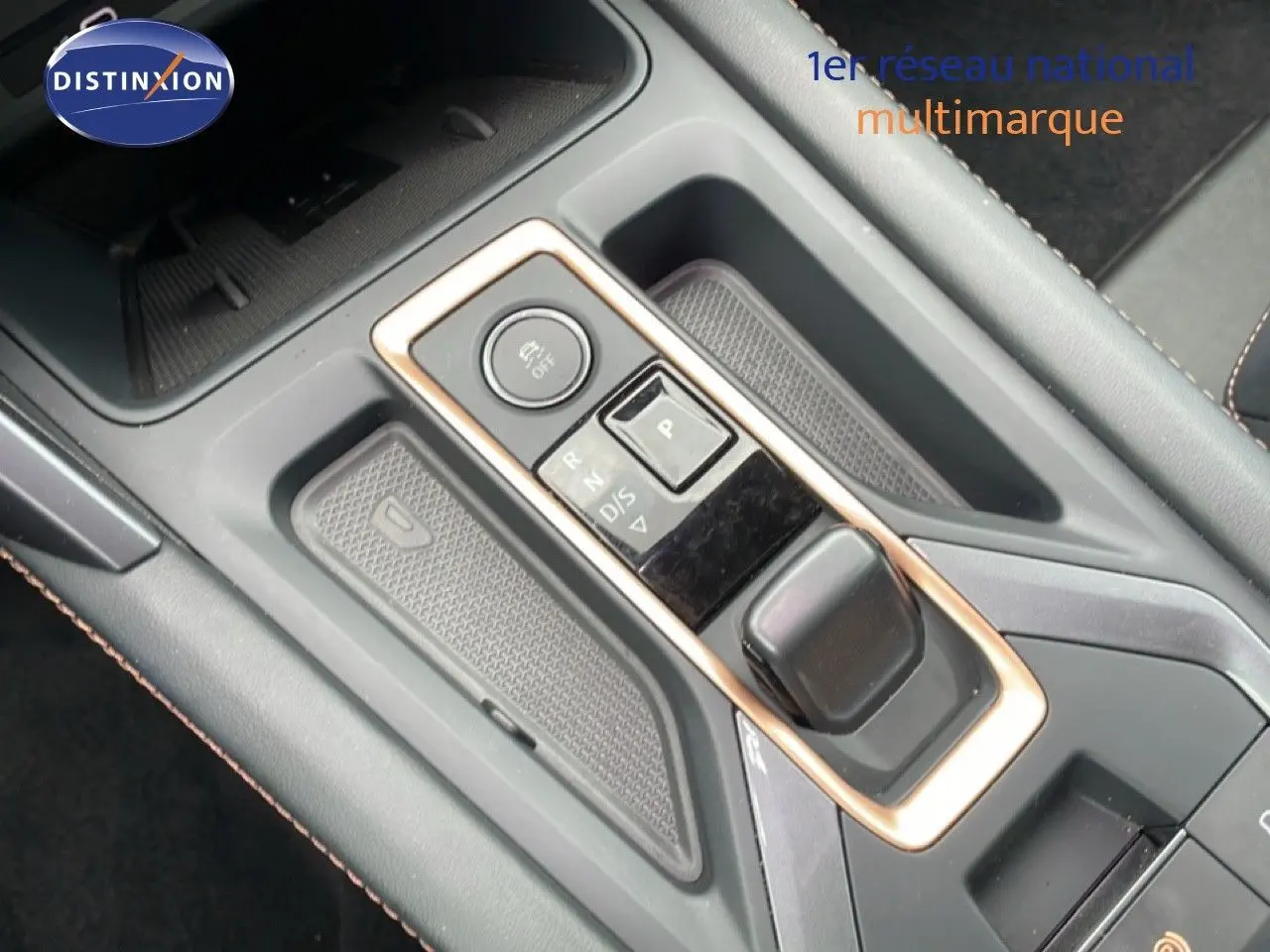 Vue en gros plan de la console centrale avec levier de vitesse électronique et surpiqûres contrastantes dans une CUPRA Formentor gris métallique.