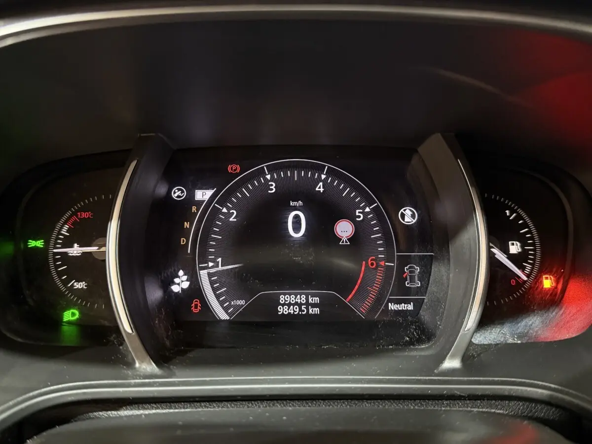 Tableau de bord numérique de Renault Mégane Intens gris foncé, affichage vitesse à 0 km/h et jauge essence rouge.