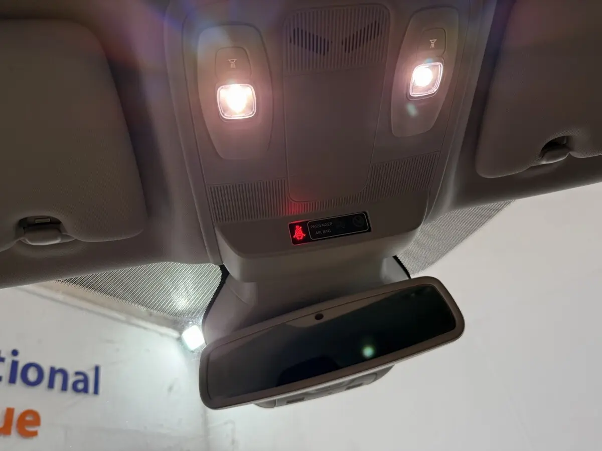 Vue intérieure en contre-plongée du plafonnier gris clair avec éclairage et rétroviseur dans une Renault Mégane gris foncé.