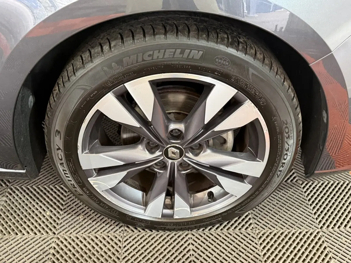 Gros plan sur la roue avant droite gris foncé de la Renault Mégane Intens avec jante alliage et pneu Michelin.