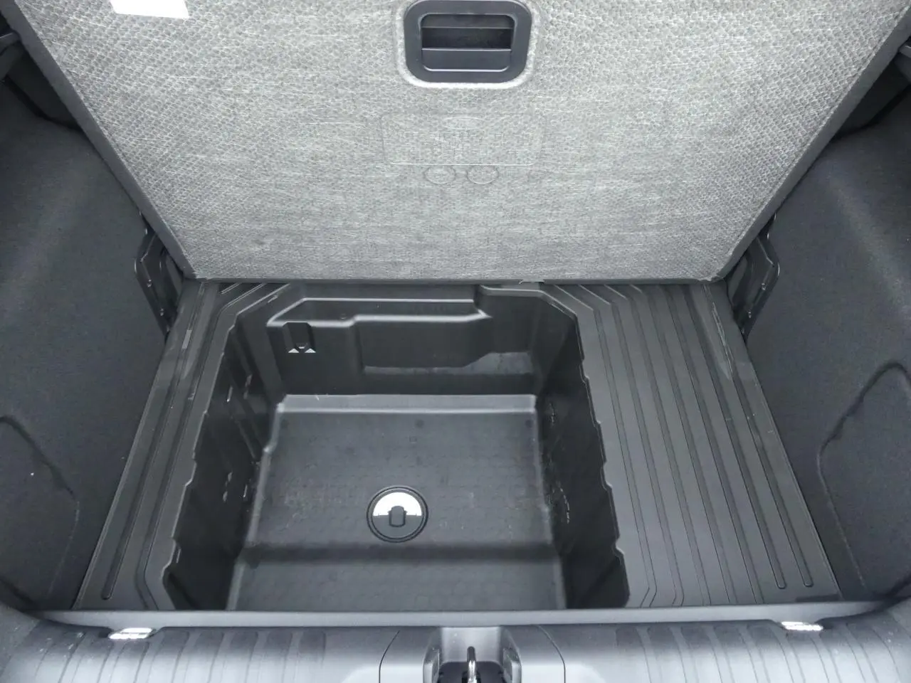 Vue plongeante sur le compartiment de rangement sous le plancher de coffre du Ford Puma 2025 gris métallisé.